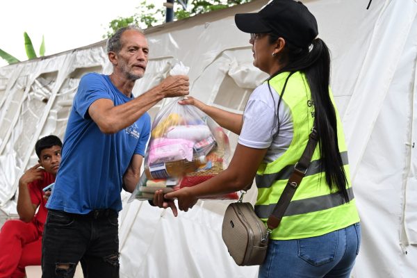 A relief worker delivers essential supplies to a resident in an earthquake-affected community in Venezuela.